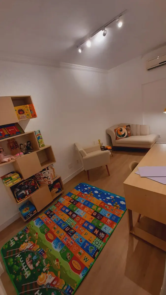 Consultório de psicologia infantil com brinquedos e tapete educativo